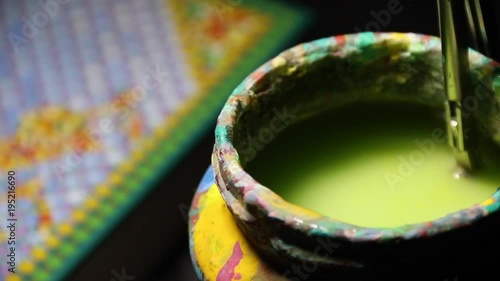 Close Up of the jar with colored water for brush and hand cleaning brush in water photo