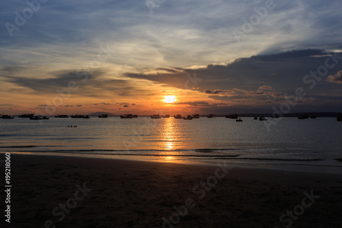 Vietnamese fishing boat silhouettes in sea at sunset