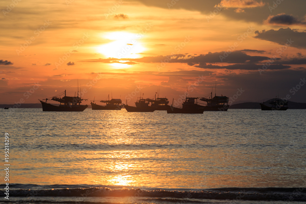 Vietnamese fishing boat silhouettes in sea at sunset