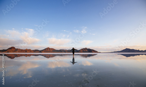 A man walking on a salt lake in the early morning