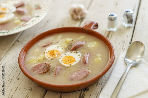 Clay pot and plate of traditional polish soup called Zurek