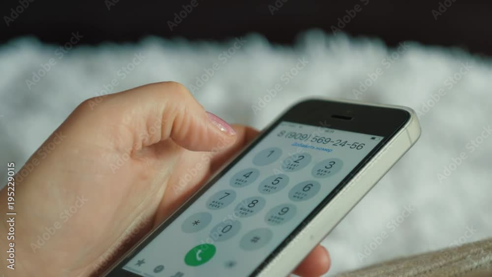 the girl holding the smartphone dials the number on the screen. the girl holding the smartphone dials the number on the screen.