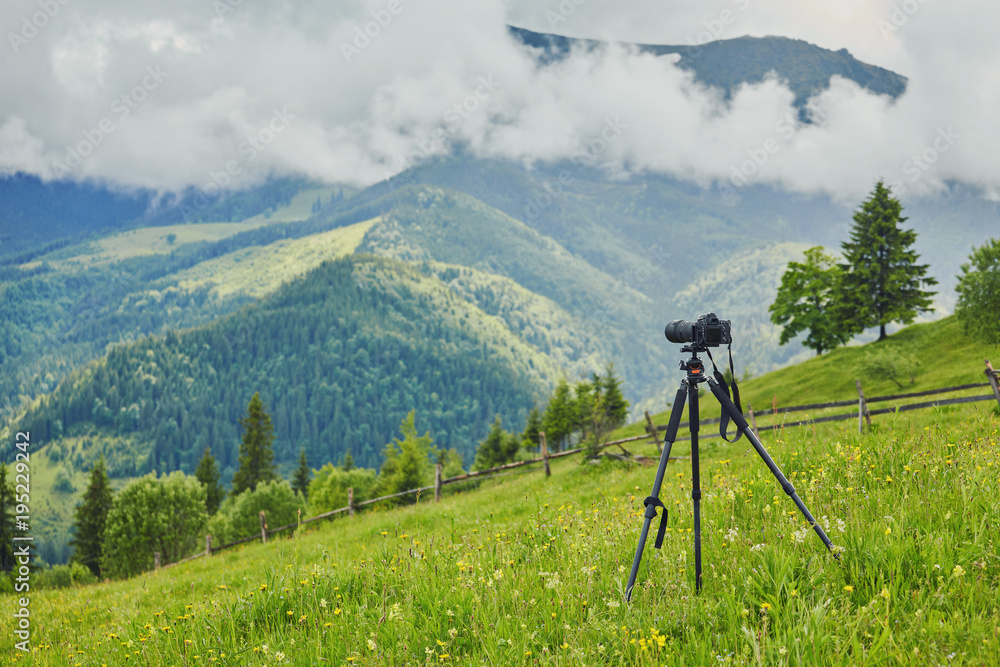 Dslr digital professional camera stand on tripod photographing mountain, Blue sky and cloud landscape.