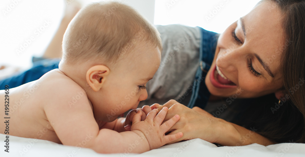 Portrait of a young mother taking care of her cute baby at home. Portrait of a young mother taking care of her cute baby at home.