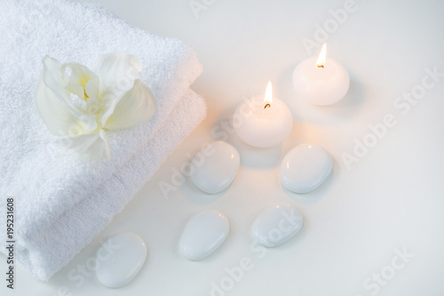 White objects on the white table  towels  stones and candles
