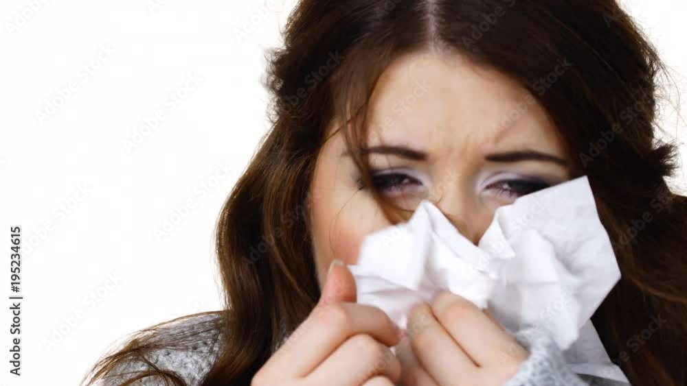 Sick freezing woman sneezing in tissue. Girl wearing warm sweater being cold and trembling. Flu or other virus. Health care Sick freezing woman sneezing in tissue. Girl wearing warm sweater being cold and trembling. Flu or other virus. Health care