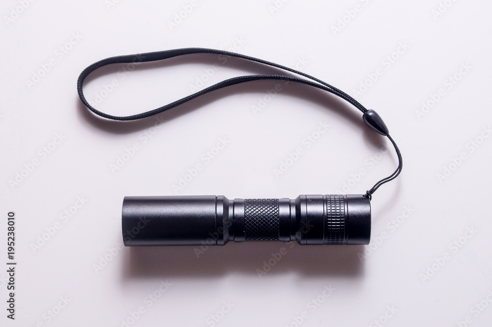 Torch with hand strap isolated on white background. LED aluminium flashlight. Black torch. Torch with hand strap isolated on white background. LED aluminium flashlight. Black torch.