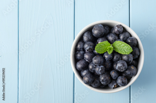 Bowl of Blueberries from Above on Painted Blue Wood Plank Table with Mint Leaves