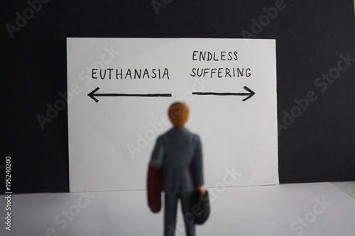Euthanasia versus endless suffering concept with miniature man and arrows. Legalization of assisted suicice for some patients theme dillema. photo