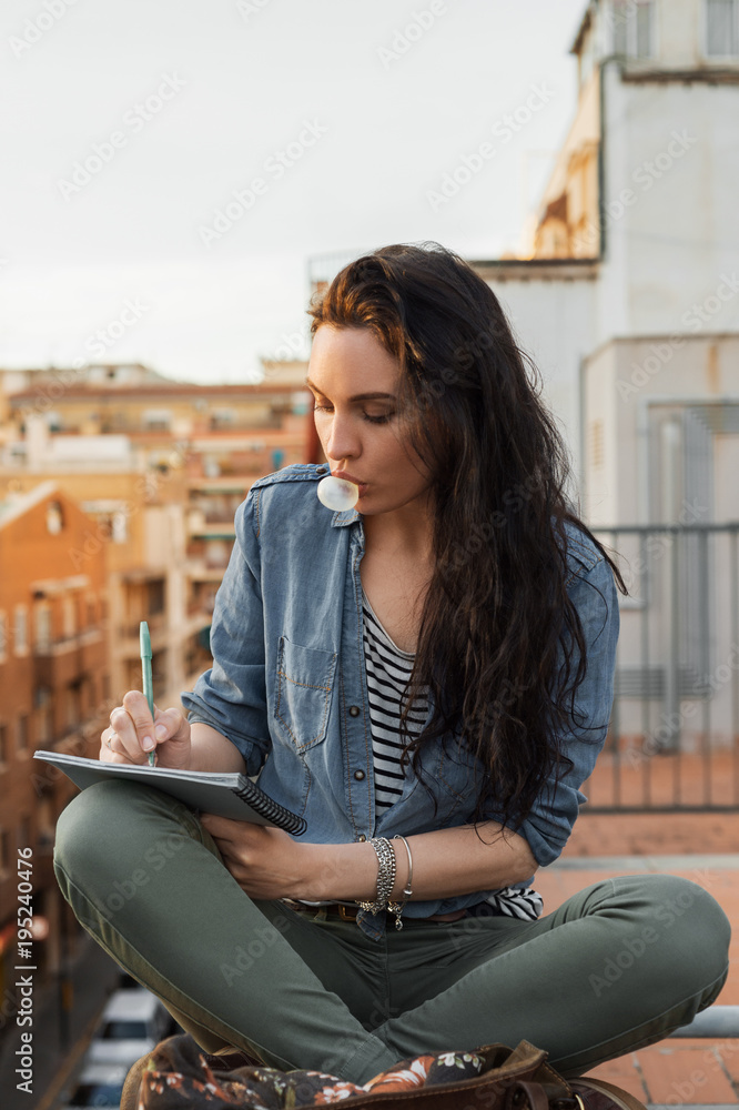 Woman with notepad on rooftop Woman with notepad on rooftop