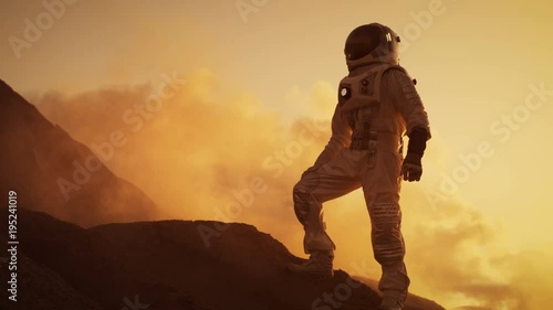Silhouette of the Astronaut Standing on the Rocky Mountain of the Alien Red Planet/ Mars. First Manned Mission on Mars. Space Exploration, Colonization. Shot on RED EPIC-W 8K Helium Cinema Camera.