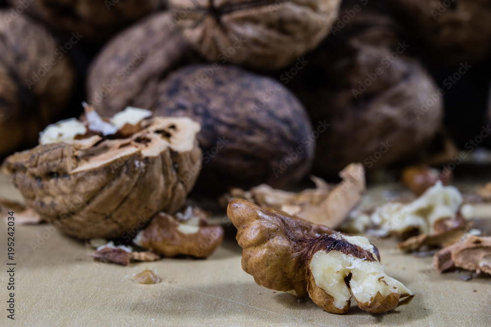 Walnuts on a wooden kitchen table. Nuts and a black wooden crate with a nutcracker.