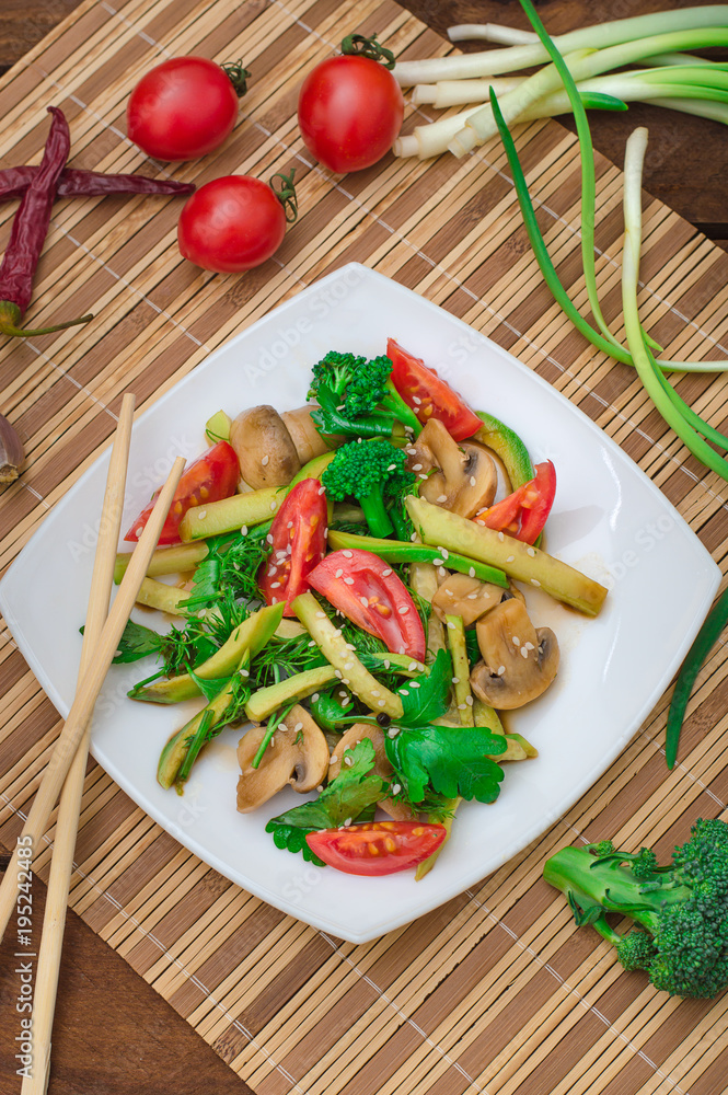 Salad with mushrooms, avocado, tomatoes and greens. Wooden rustic background. Top view Salad with mushrooms, avocado, tomatoes and greens. Wooden rustic background. Top view