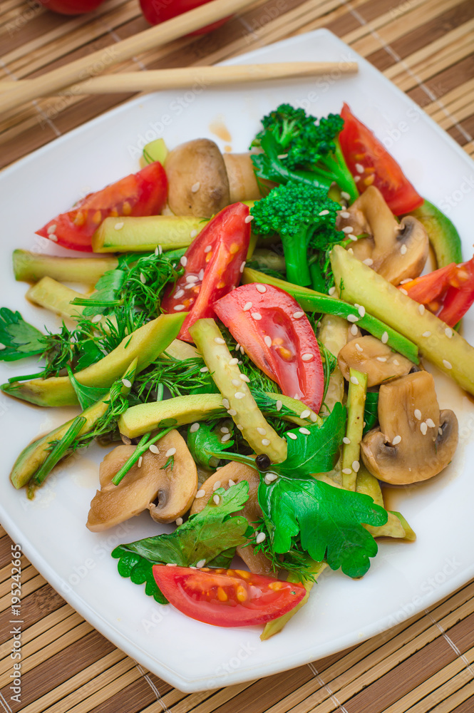 Salad with mushrooms, avocado, tomatoes and greens. Wooden rustic background. Top view Salad with mushrooms, avocado, tomatoes and greens. Wooden rustic background. Top view