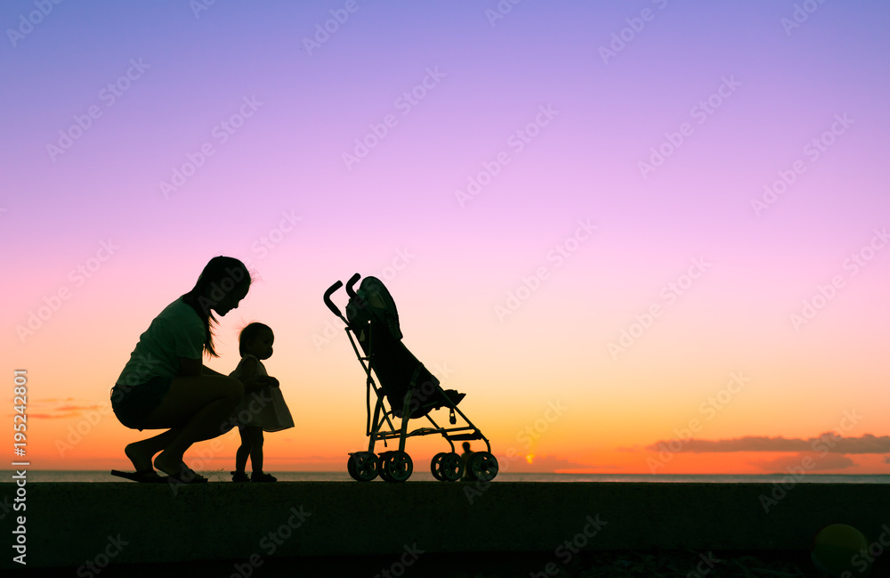 Obraz premium Mother enjoying the sunset with her little girl. Parenting, and child care concept. 