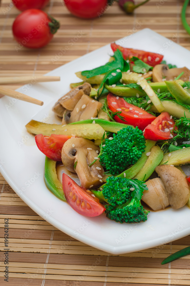Salad with mushrooms, avocado, tomatoes and greens. Wooden rustic background. Top view Salad with mushrooms, avocado, tomatoes and greens. Wooden rustic background. Top view