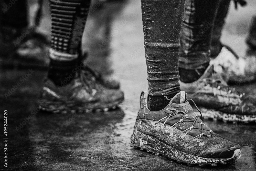 Black and white muddy dirty shoes after trail running run Stock Photo
