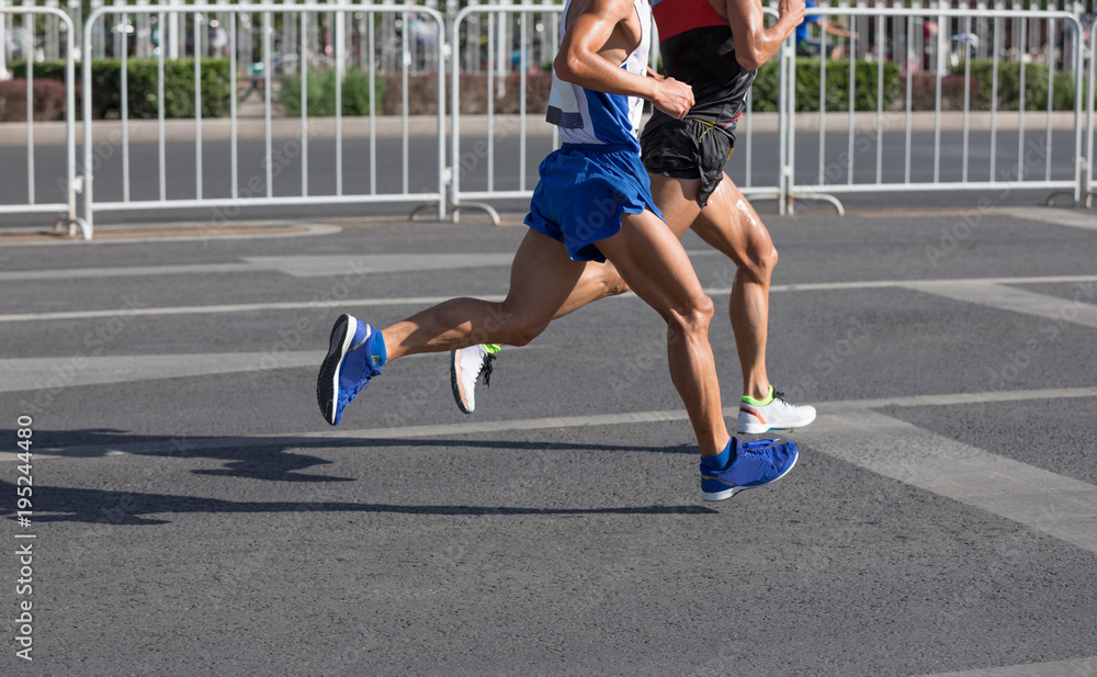 Fototapeta premium Legs of marathon runners running on city road