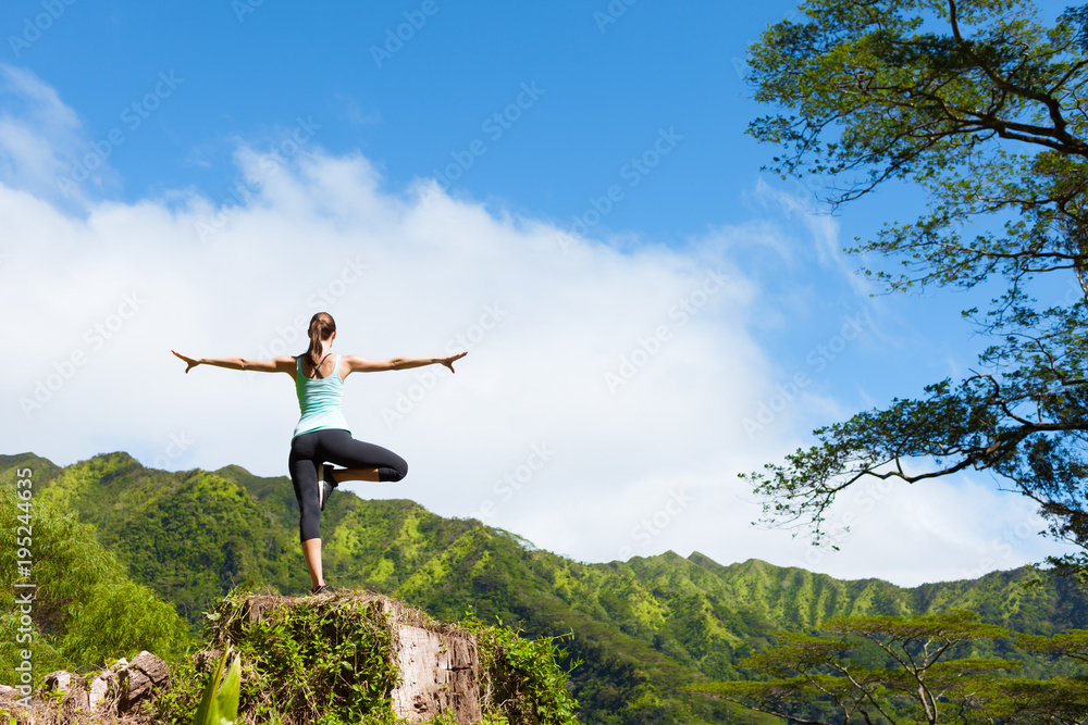 Woman doing a balancing yoga pose on a mountain. Woman doing a balancing yoga pose on a mountain.