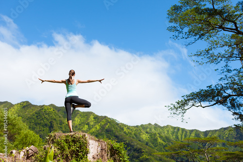 Woman doing a balancing yoga pose on a mountain. 