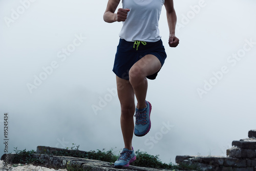 sporty fitness woman runner running on mountain top