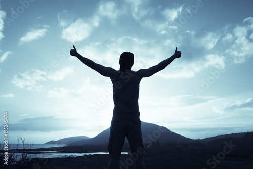 Positive feelings. Man standing on a mountain feeling happy, and free. Thumbs up! © kieferpix