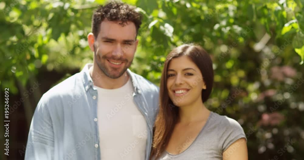 4K Portrait attractive couple smiling to camera, standing in green natural environment. Slow motion. 4K Portrait attractive couple smiling to camera, standing in green natural environment. Slow motion.