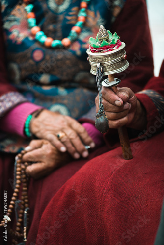 Traditional tibetian man holding prayer wheel. Ladakh. India photo