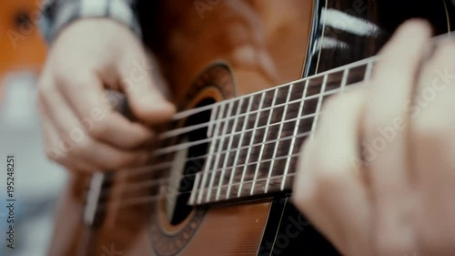 The guy plays a classical guitar in a music store, a musical mood, classical music