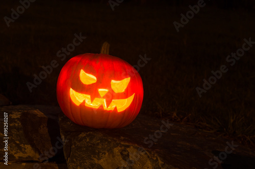 Spooky Halloween Pumpkin in the Dark night on a stone wall