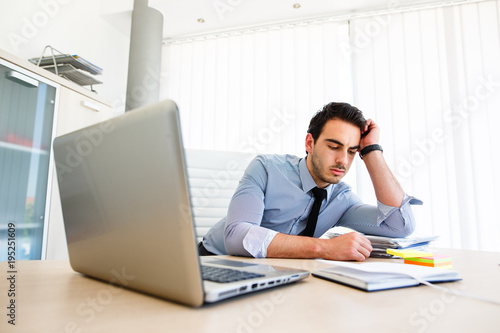 Lonley tiresome businessman spending time at work