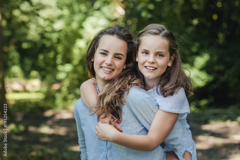 Sweet summer portrait of two happy sisters Sweet summer portrait of two happy sisters