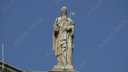 A saint statue on top of a budiling photo