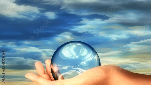 A hand holding a clear golbe