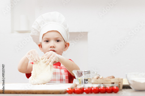 Little child making pizza o...