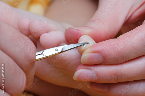 Family activity mother hand cut nails for kid by using nail scissors
