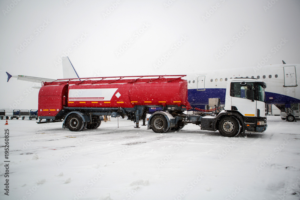refueling aircraft winter snow. Refueling the aircraft with kerosene at the airport in winter during a snow blizzard