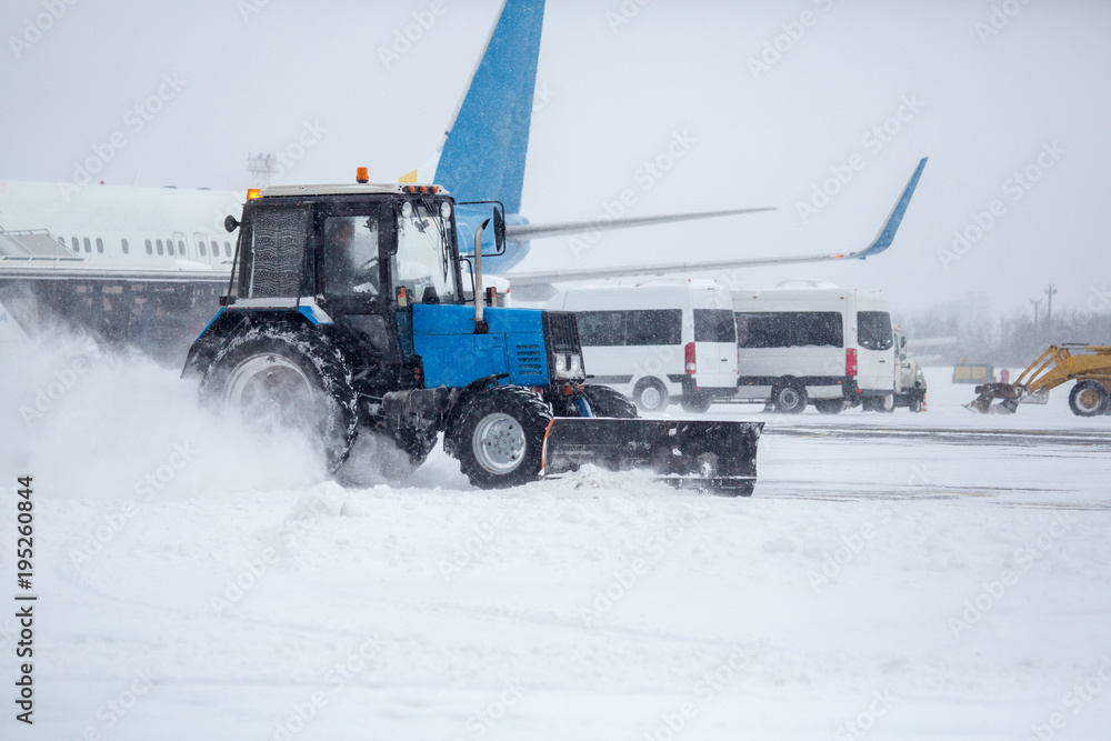 Clearing airport from snow during snow storm. clearing runway from snow. Clearing snow with bulldozers from airport aprons. Clearing airport from snow during snow storm. clearing runway from snow. Clearing snow with bulldozers from airport aprons.