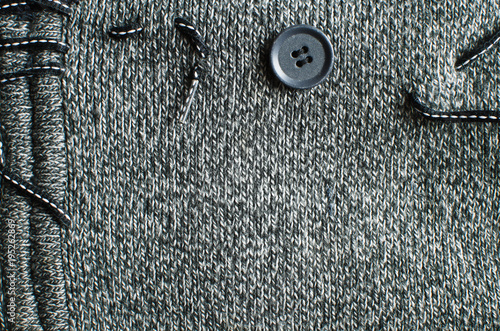 grey knitted wool background, seam, lace-up and button closure