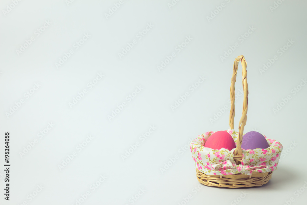 Easter eggs in a basket weave wood on the right corner on a white background.