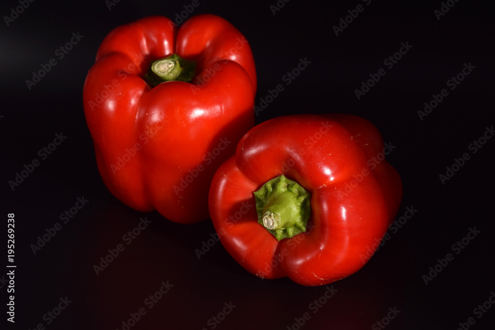 Bright red peppers on a seamless black background. Bright red peppers on a seamless black background.