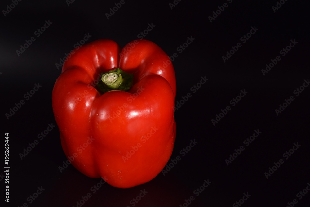 Bright red peppers on a seamless black background. Bright red peppers on a seamless black background.