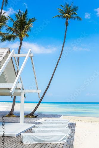 a landscape photo of the sea shore and a wooden house with a playground for sun beds. concept of summer holidays on the ocean