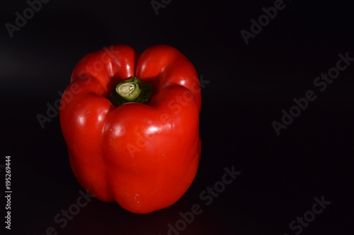 Bright red peppers on a seamless black background. 