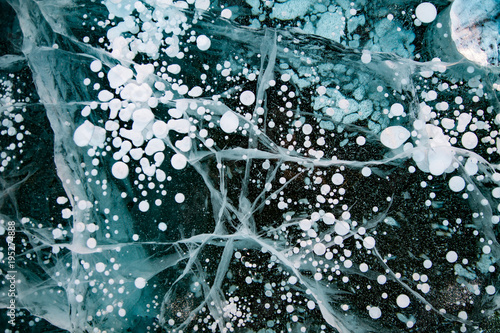 blue thick layer of ice on a river with lots of cracks