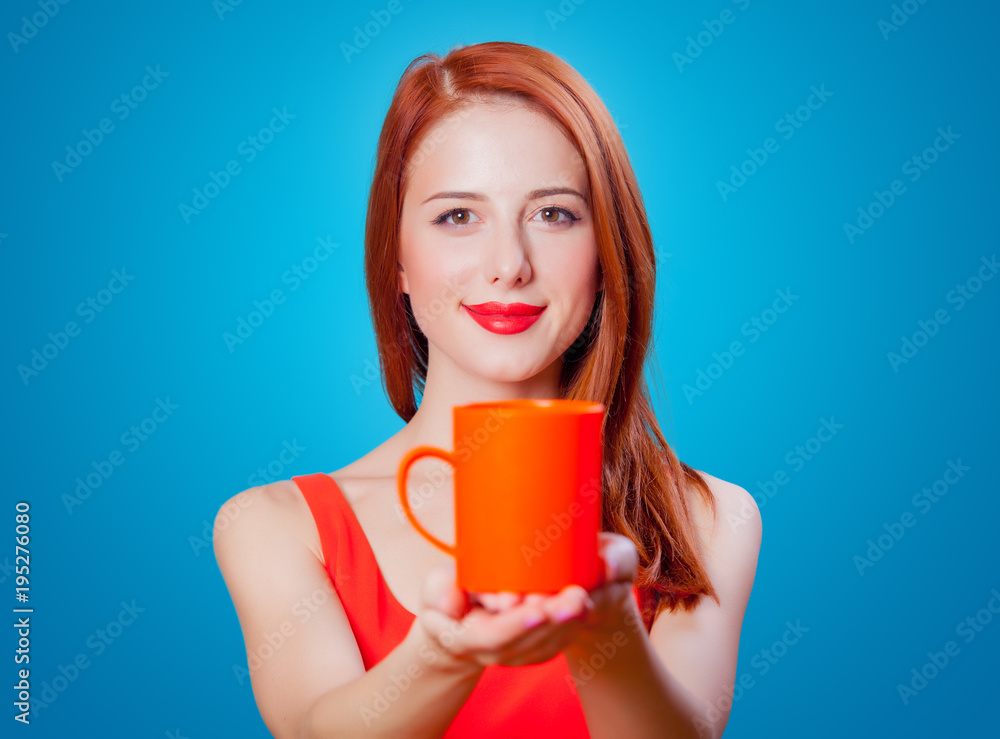 Redhead girl with coral cup of coffee or tea Redhead girl with coral cup of coffee or tea