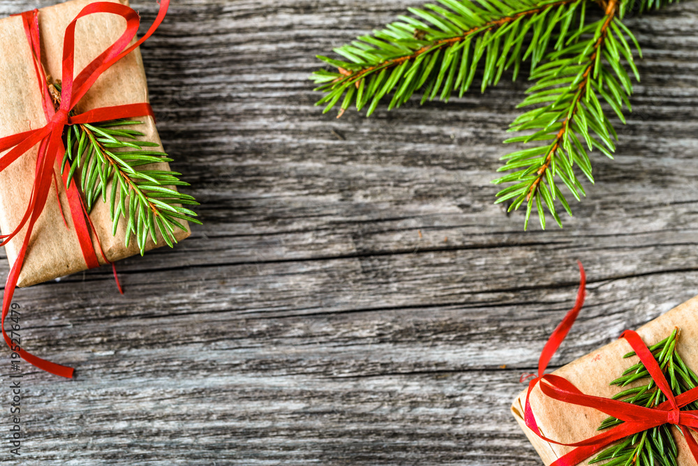 Christmas gift boxes, presents in rustic package with green fir branch on wooden rustic background Christmas gift boxes, presents in rustic package with green fir branch on wooden rustic background