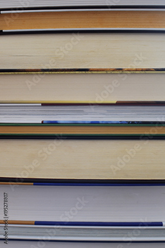 Stack of book with different color tone of sheets and colorful covers as background. Pile of old and new book. Education concept.