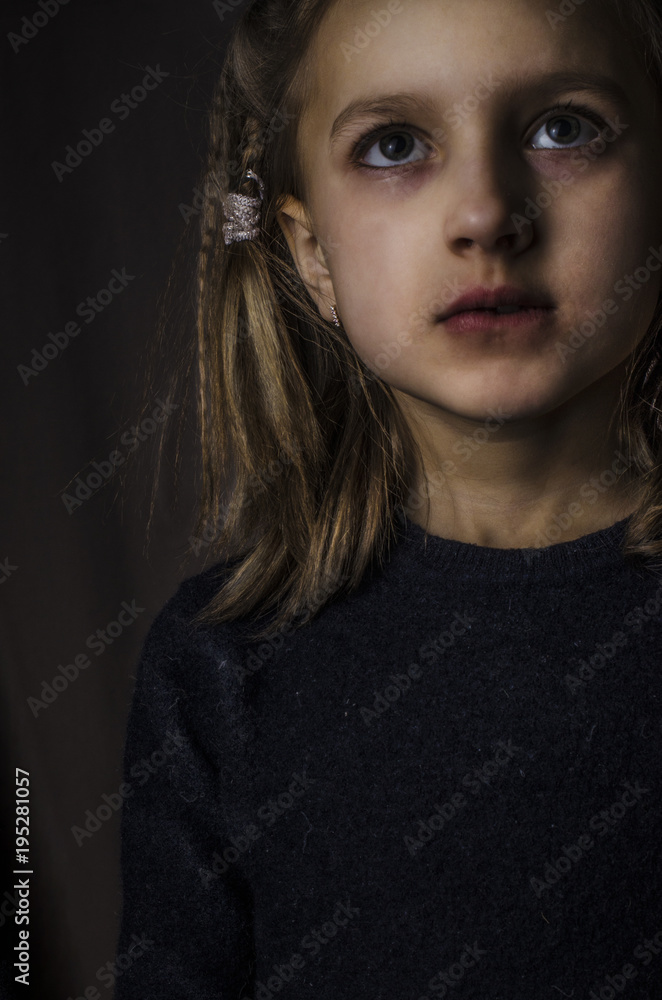 A girl with a sad look on a dark background A girl with a sad look on a dark background