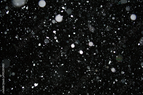Photo of a snow falling at night, beautiful background